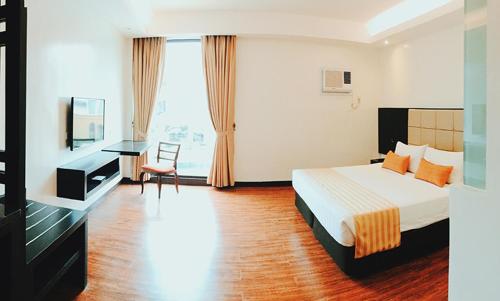 um quarto de hotel com uma cama e uma secretária em Hotel Oazis em Butuan
