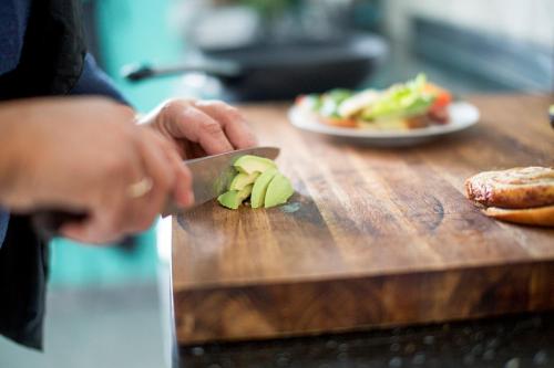 a person cutting up an apple on a cutting board at Unstad Arctic Resort in Unstad