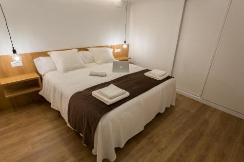 1 dormitorio con 1 cama grande y ordenador portátil en SunShine Arco de San Francisco, en Córdoba