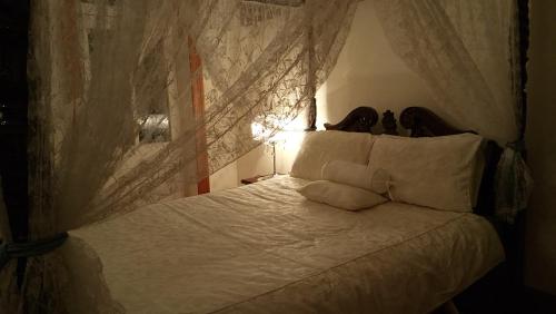 a bed with white sheets and pillows in a room at Natone in Hobart