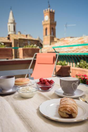 a table with cups and plates of food on it at La Bellavita B&B in Pienza