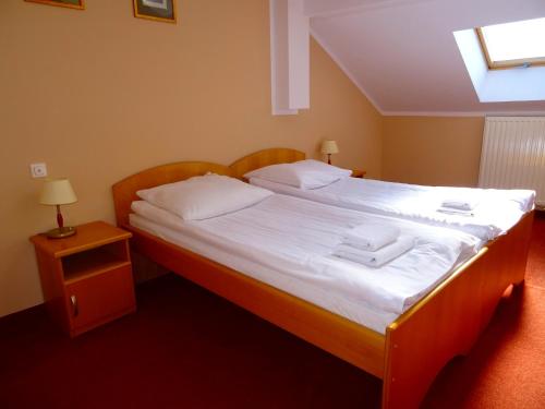 a bedroom with a large bed with white sheets at Hotel Bartis in Bartoszyce