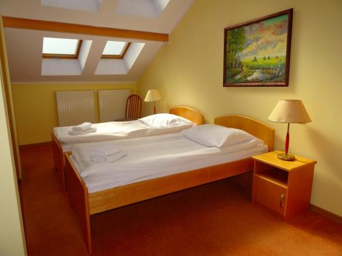 a bedroom with a bed and a lamp on a table at Hotel Bartis in Bartoszyce