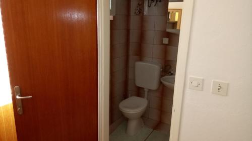 a bathroom with a toilet and a sink at Apartment Burin Dvor in Rab