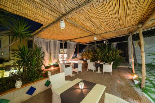 a restaurant with white tables and chairs and plants at Aquarius Maiori B&B in Maiori