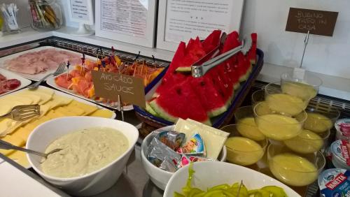 a counter with a bunch of different types of food at Hotel Houston Suites in Rimini