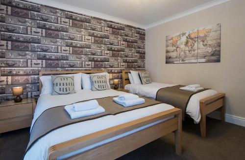 a bedroom with two beds and a brick wall at Thornbank House Offering Breakfast and with the use of Free Local Health Club in Windermere