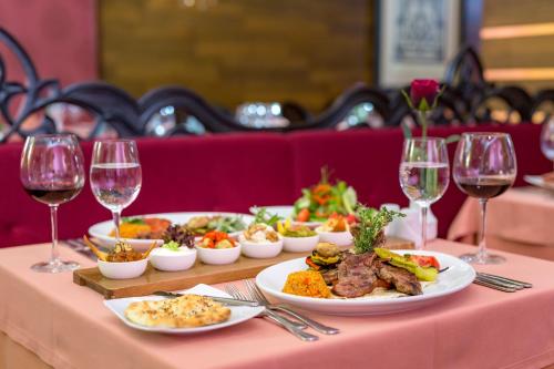 a table with plates of food and glasses of wine at Royal Holiday Palace in Lara