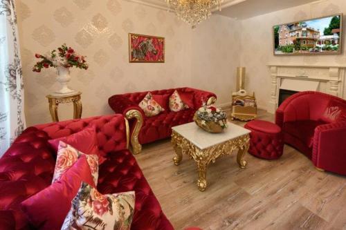 a living room with red couches and a fireplace at Boutiquehotel Villa Rosenhof in Badenweiler