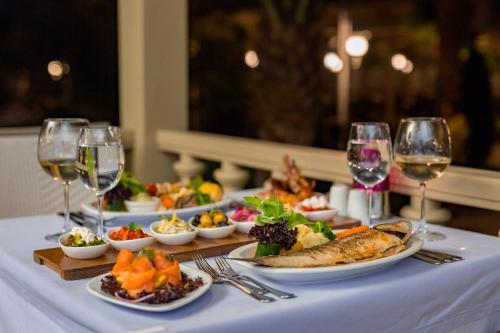 a table with plates of food and glasses of wine at Royal Holiday Palace in Lara