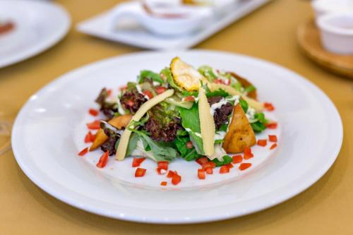 a white plate with a salad on a table at Royal Holiday Palace in Lara