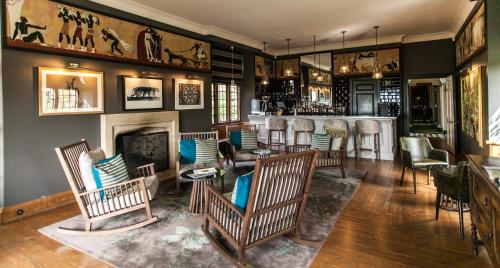 a bar with rocking chairs and a fireplace at Port Lympne Mansion Hotel in Hythe