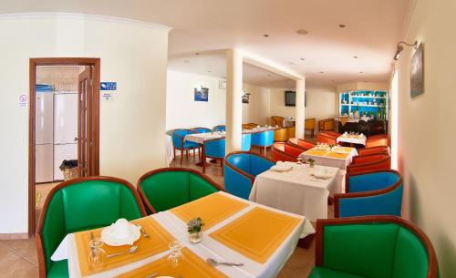 a dining room with tables and chairs in a restaurant at Alojamento Bela Vista in Lajes do Pico