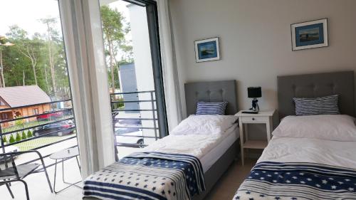 Un pat sau paturi într-o cameră la Pobierowo Apartments