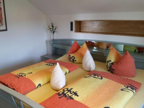 2 Betten mit bunten Kissen auf einem Zimmer in der Unterkunft Ferienwohnung Hein in Iphofen