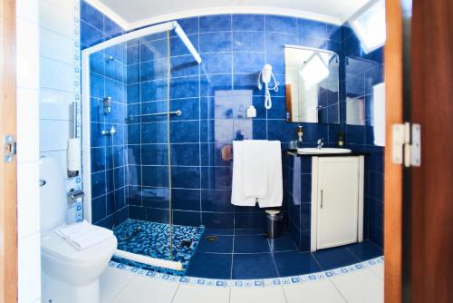 a blue tiled bathroom with a toilet and a sink at Alojamento Bela Vista in Lajes do Pico