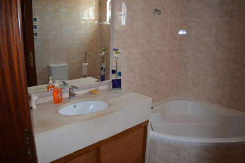 a bathroom with a sink and a bath tub at Villa Marquês in Vila Nova da Barquinha