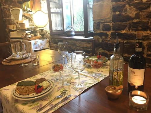 a table with a bottle of wine and wine glasses at Podere Terreno alla via della volpaia in Radda in Chianti