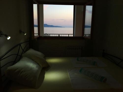 a bedroom with two beds and a large window at Apartman Mimoz in Senj