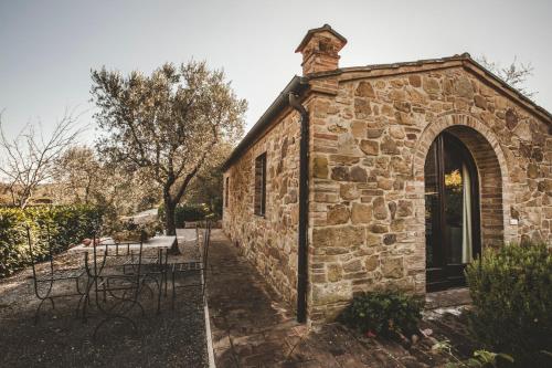 a brick building with tables and chairs in a yard at Agriturismo Zampugna in Montefollonico