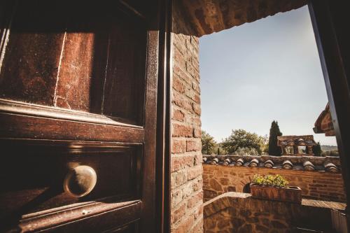 an open door with a window and a brick wall at Agriturismo Zampugna in Montefollonico