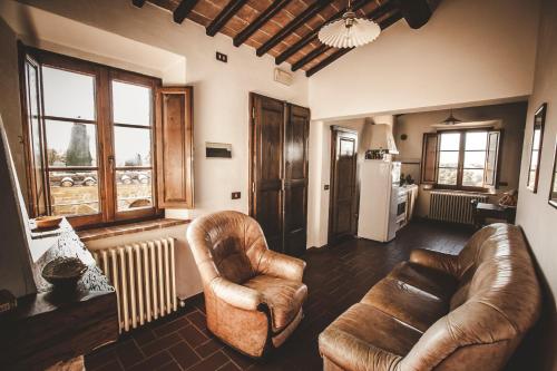 a living room with two leather chairs and a refrigerator at Agriturismo Zampugna in Montefollonico