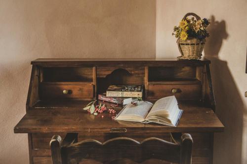 a table with an open book and a vase of flowers at Agriturismo Zampugna in Montefollonico