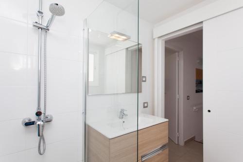 a bathroom with a shower and a sink at TAO Caleta Playa in Corralejo