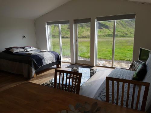 1 dormitorio con cama y ventana grande en Bólstaðarhlíð - Cottage (studio) en Bólstaðarhlíð