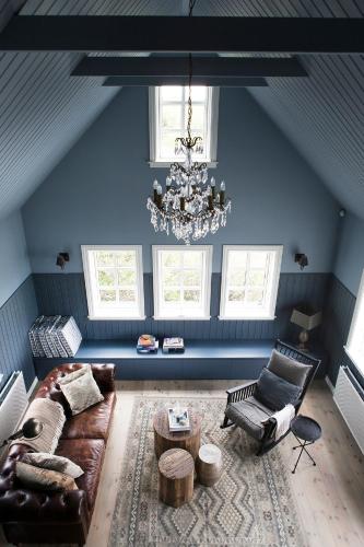a living room with a couch and a chandelier at Black timber house in Borgarnes