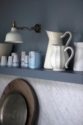 a shelf with white vases and a lamp on it at Black timber house in Borgarnes