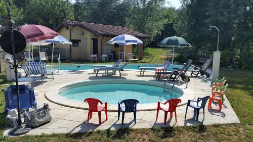 a pool with chairs and tables and umbrellas at Cascina Rosa Camilla in Carpeneto