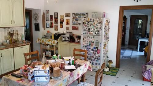 a kitchen with a table and a refrigerator at Cascina Rosa Camilla in Carpeneto