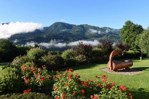 a statue of a goose in a garden with mountains in the background at Agritur Maso Chemela in Cavalese