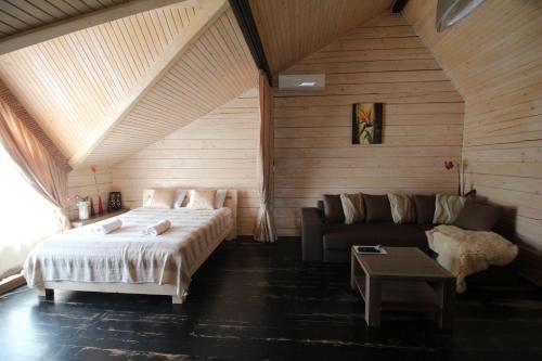 a bedroom with a bed and a couch in a room at Villa Kaiser in Lviv