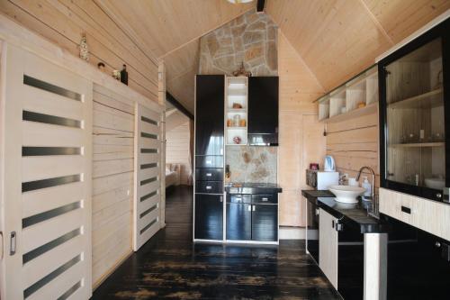 a kitchen with wood paneled walls and a kitchen with black appliances at Villa Kaiser in Lviv