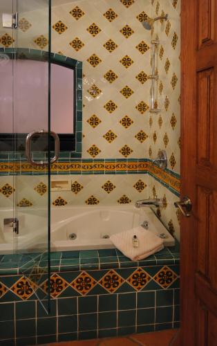 a bathroom with a tub and a tile wall at Casa Estrella de la Valenciana Hotel Boutique in Guanajuato