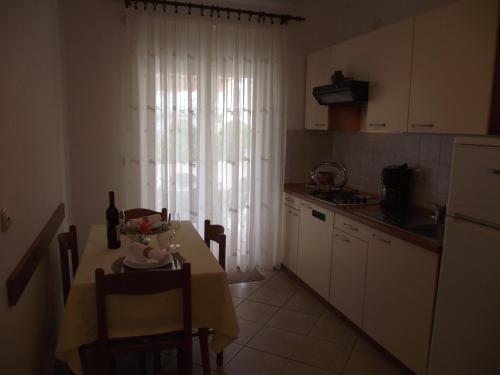 a small kitchen with a table with a yellow table cloth at Apartments Dajana Silo in Šilo