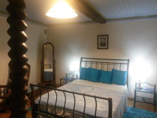a bedroom with a bed with blue pillows at Casa das Freiras in Marialva