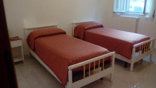 1 dormitorio con 2 camas y ventana en Casa Paradiso en Brindisi
