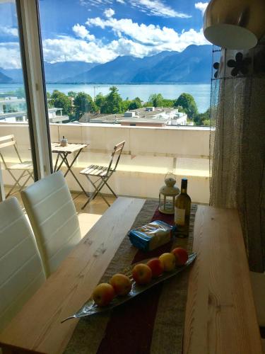 a table with a plate of fruit on top of a balcony at Spacious Apartment with Lake View | 35 in Montreux