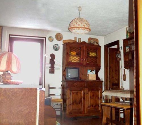 a living room with a tv and a wooden cabinet at Isa in La Thuile