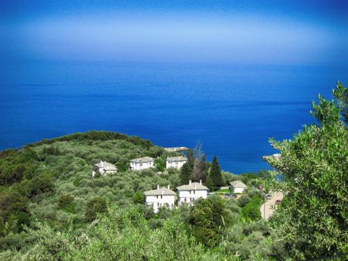 a house on a hill next to the ocean at Red Villa's Guesthouse in Tsagarada