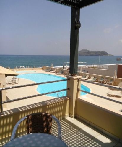 a balcony with a view of a swimming pool at Lissos Beach in Plataniás