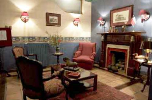 a living room filled with furniture and a fire place at Hotel Isla Rey Jorge in Punta Arenas