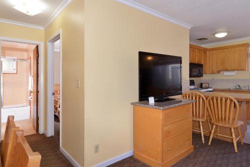 a kitchen with a flat screen tv on a dresser at Surf Motel and Gardens in Fort Bragg