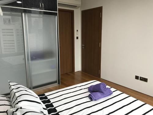 a bedroom with a bed with a purple towel on it at VORTEX SUITES KLCC by PNUT With NETFLIX in Kuala Lumpur