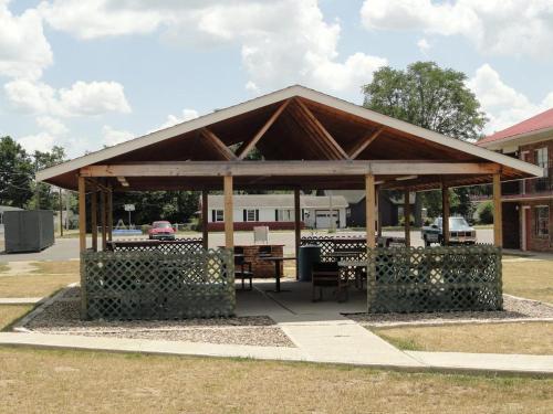 a pavilion with a table and chairs in front of a building at Red Carpet Inn (formerly Royal Inn) in Terre Haute