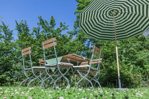 two chairs and an umbrella sitting next to sidx sidx sidx at Hotel B&B "Zur Schanz" in Ebbs