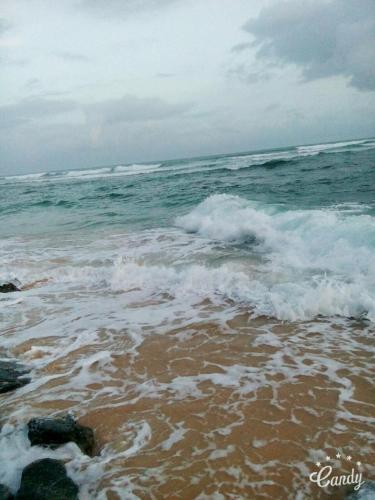 a beach with the ocean and waves at Villa Gaetano Unawatuna in Unawatuna
